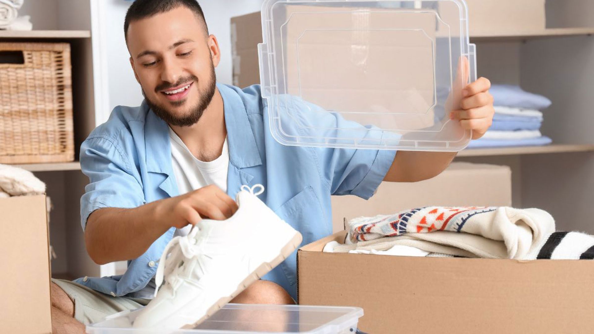 man putting shoes into a plastic bin