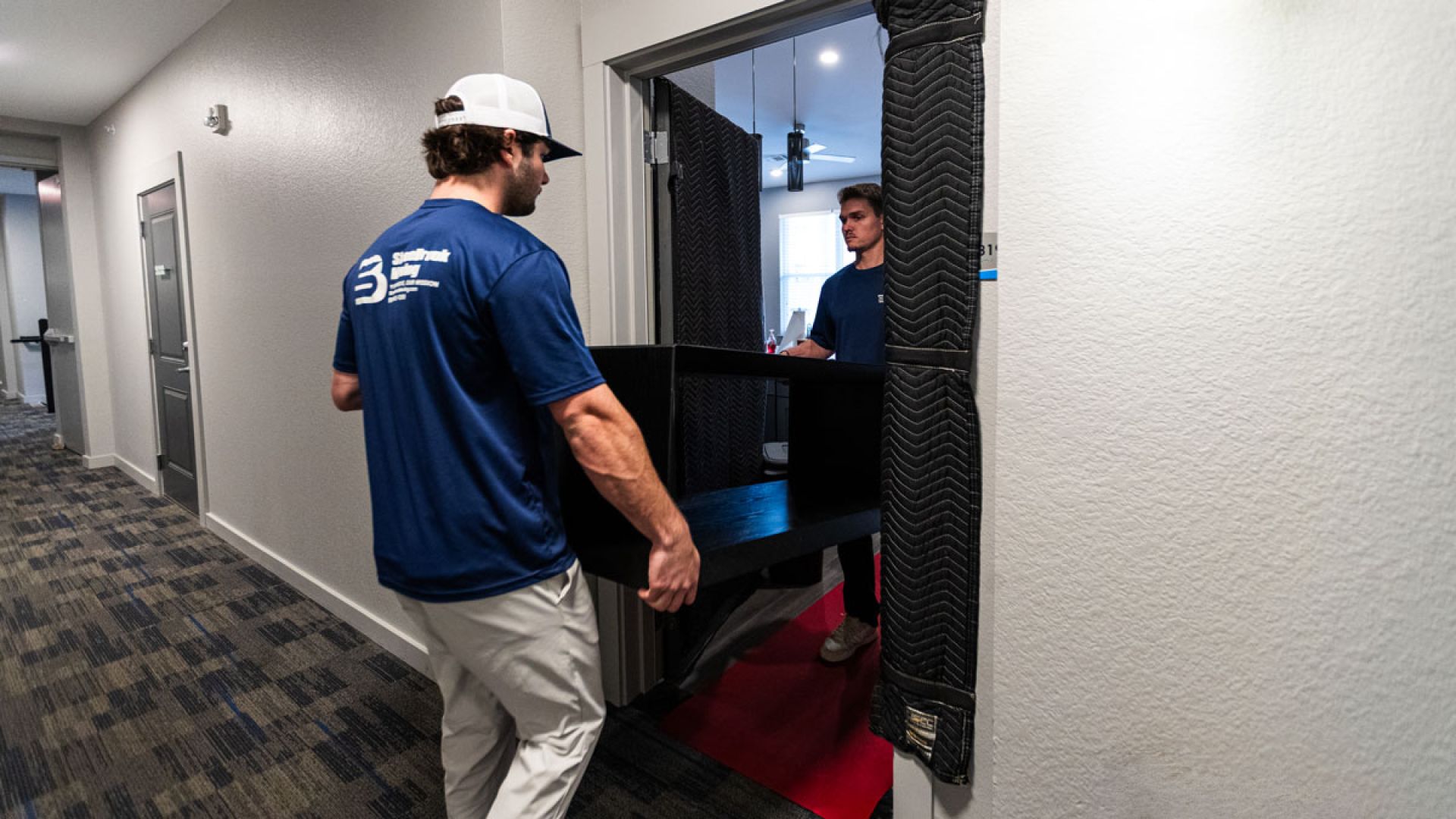two men moving furniture out of an apartment