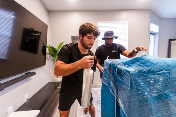 StoneBrook Moving wrapping furniture in padding and plastic wrap